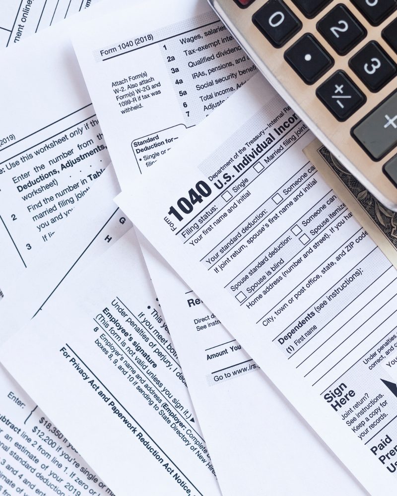Tax forms and a calculator on a desk